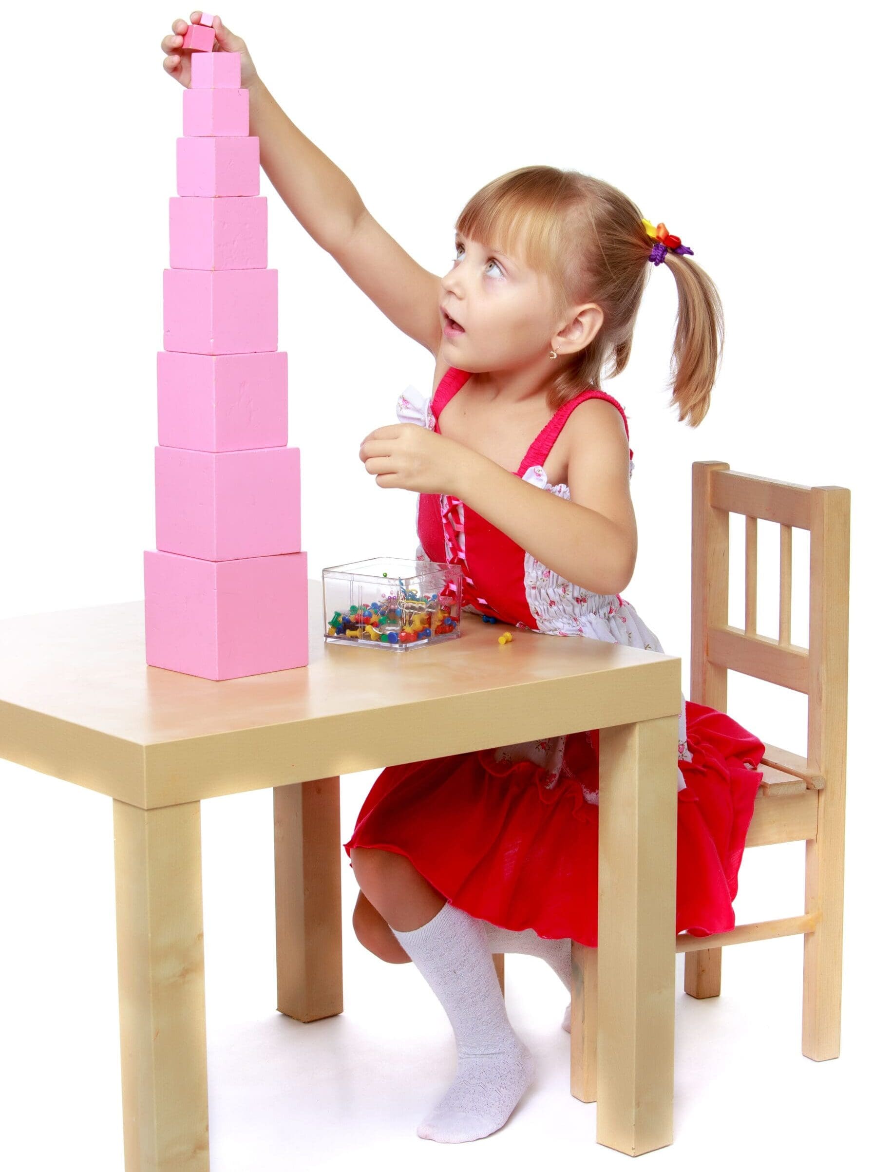 Child using montessori pink tower blocks - Toddler Toys Child using montessori pink tower blocks