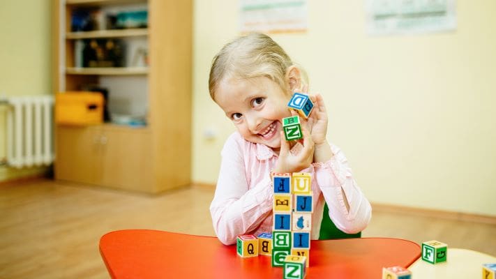 girl playing with alphabet blocks