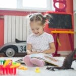 girl smiling and reading best interactive books