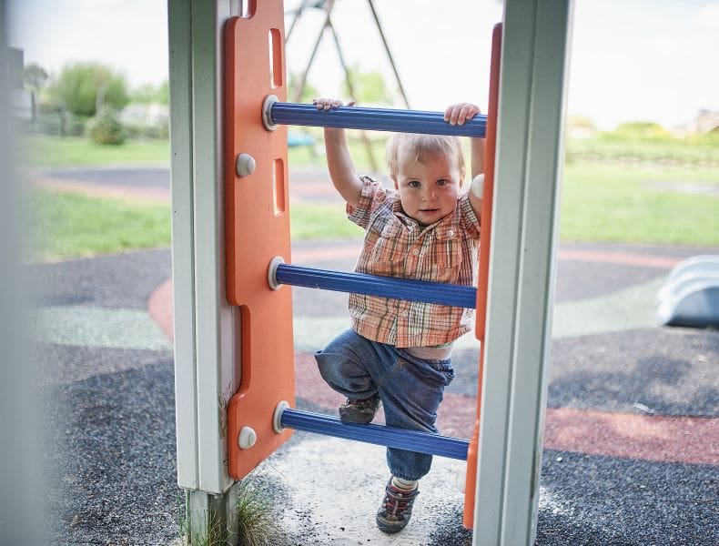 Toddler climbs on the slide on the playground