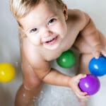 a baby holding a round colorful toys