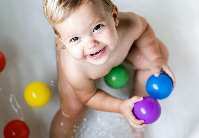 a baby holding a round colorful toys - Toddler Toys a baby holding a round colorful toys