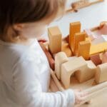 child playing with wooden block toys